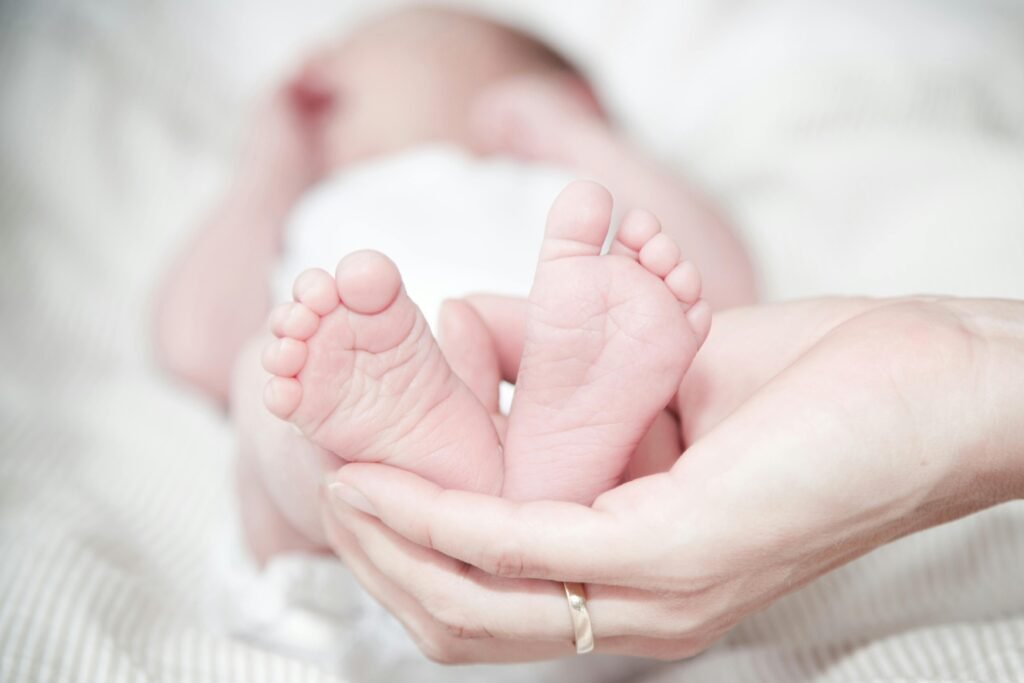 Füße eines Babys in einer Hand
