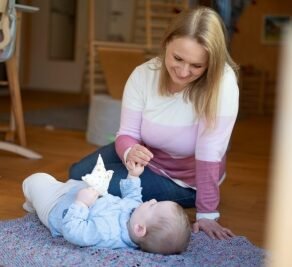 Frau sitzend mit liegendem Baby