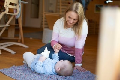 Frau sitzend mit liegendem Baby